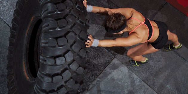 Tire-Flip Fit woman working out with tire