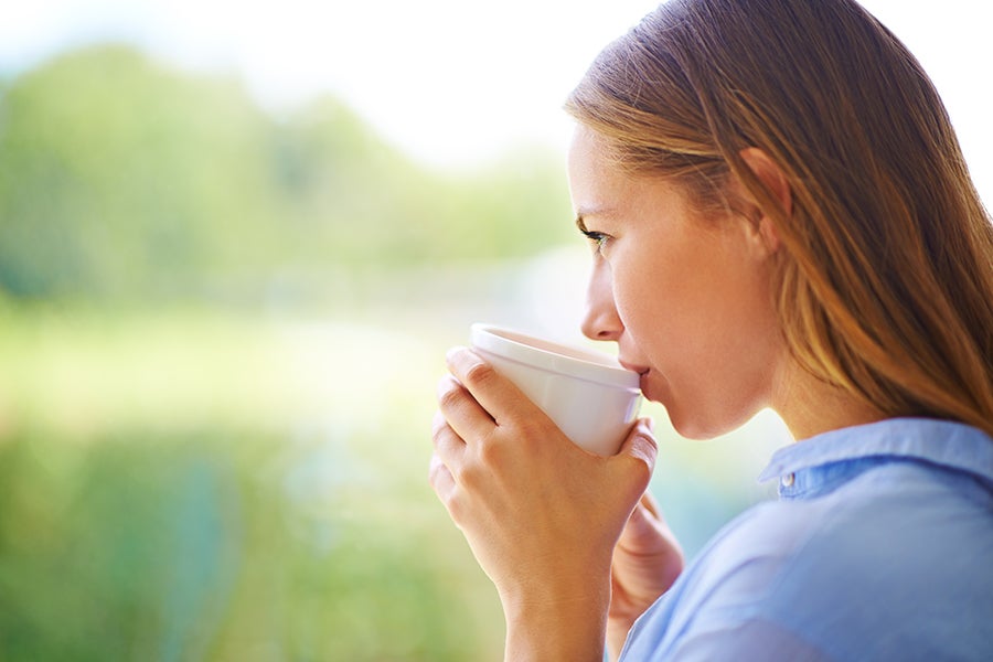 Daydreaming Woman daydreaming with coffee in her hand