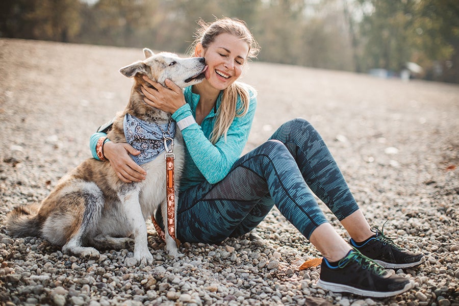 Dog Article Fit woman with dog giving kisses