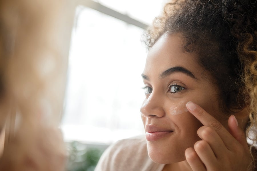 Skincare Woman doing skincare in the mirror