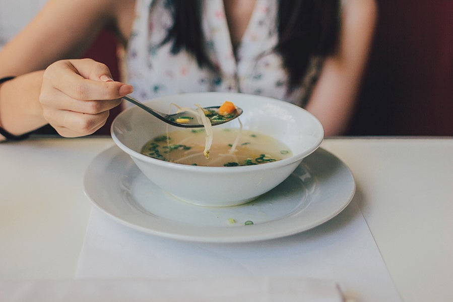 soup-main Woman eating bone broth soup