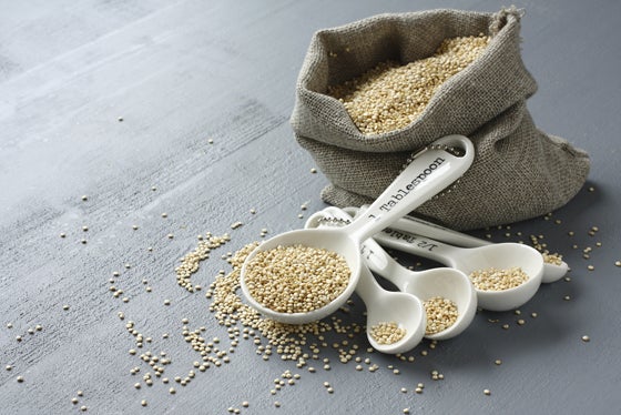 Quinoa grain in small burlap sack and porcelain measuring spoons