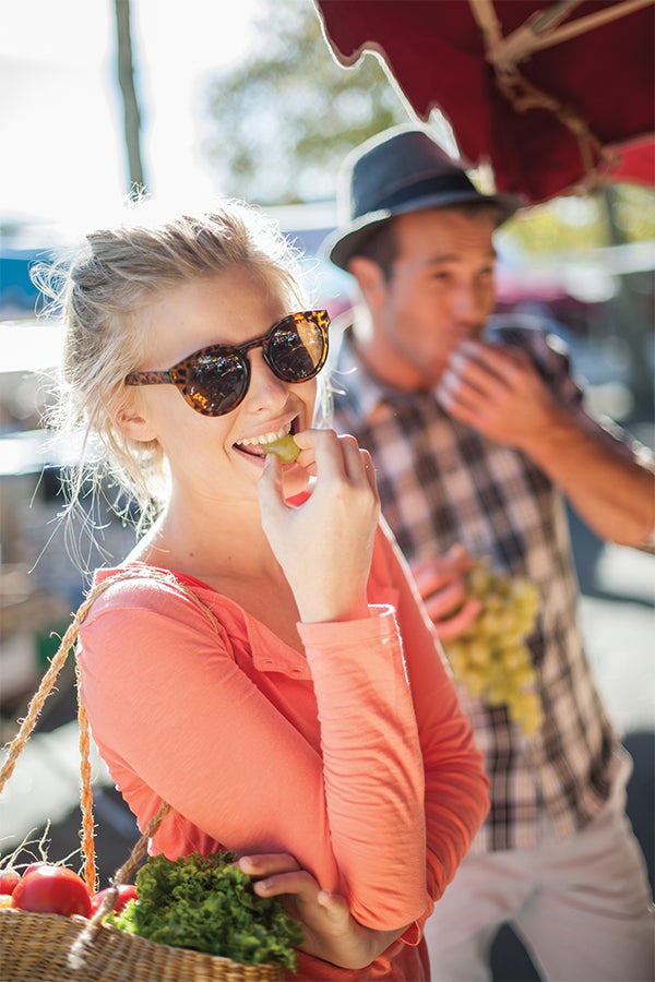 Ask the Nutritionist Woman eating fruit at the market