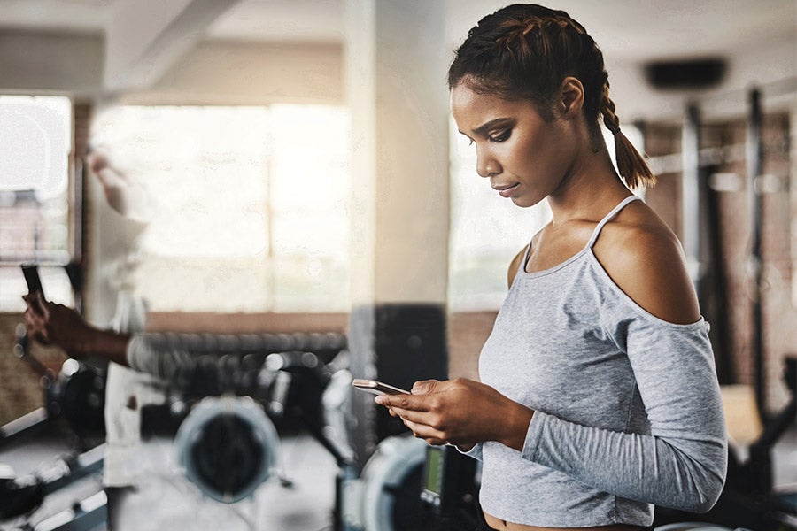 Fit woman on her phone at the gym