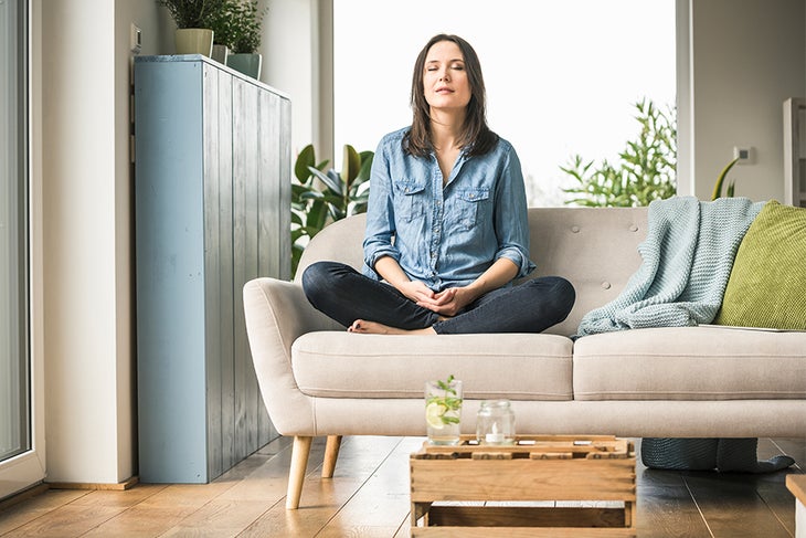 Relaxing Image Woman closing her eyes and relaxing on a couch