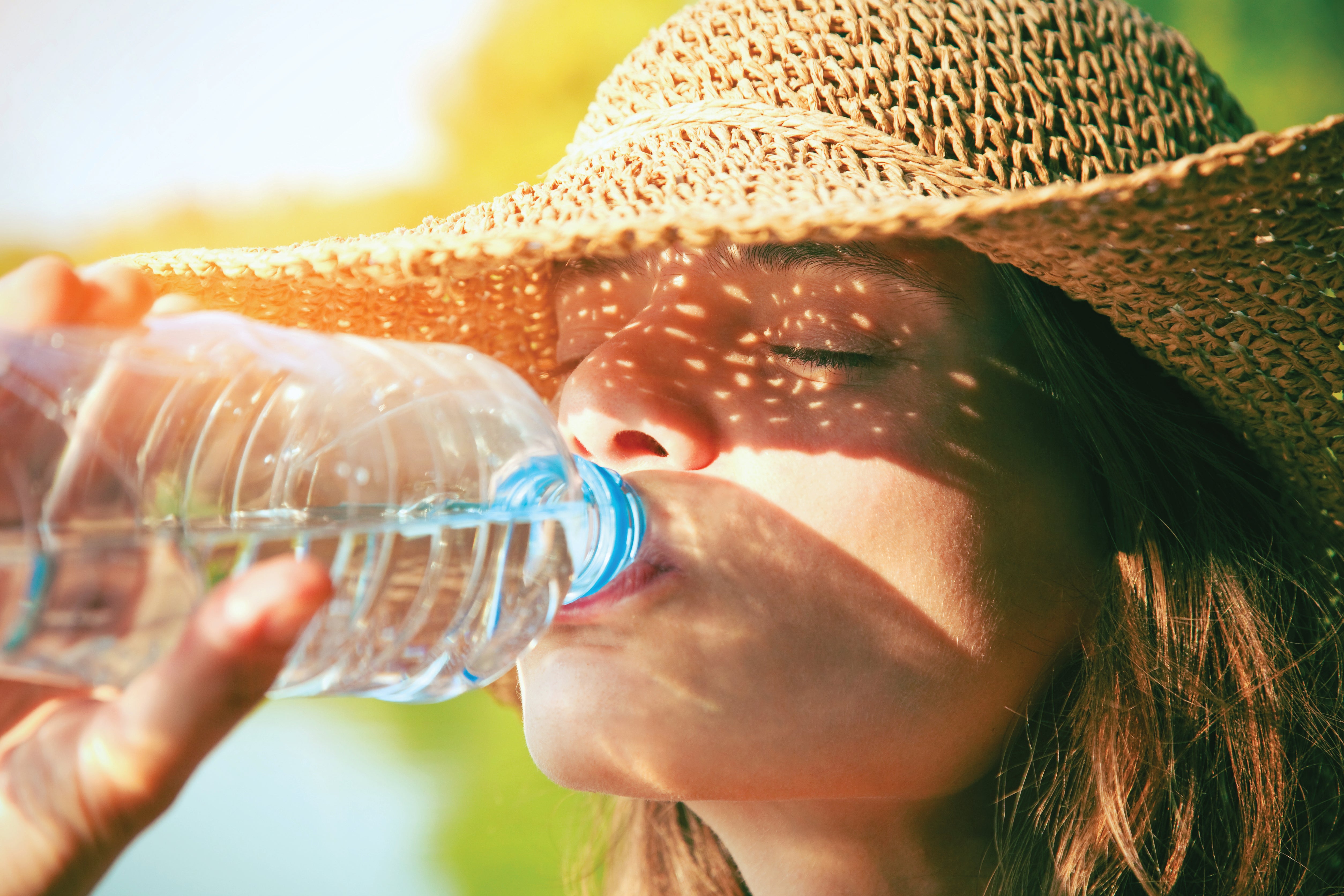 Woman drinking water in the summer outdoors