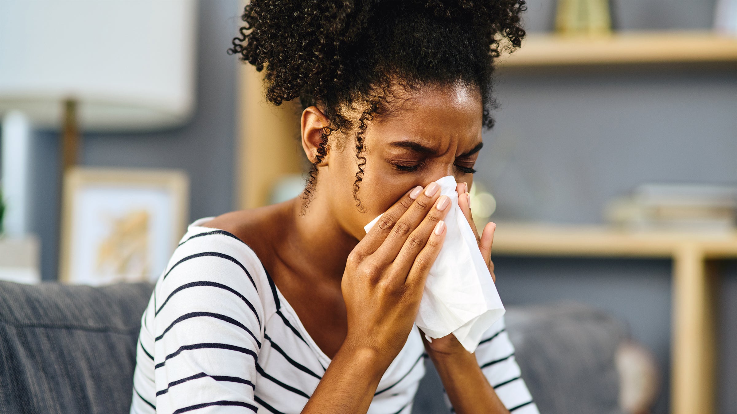 Woman Sneezing into a Tissue