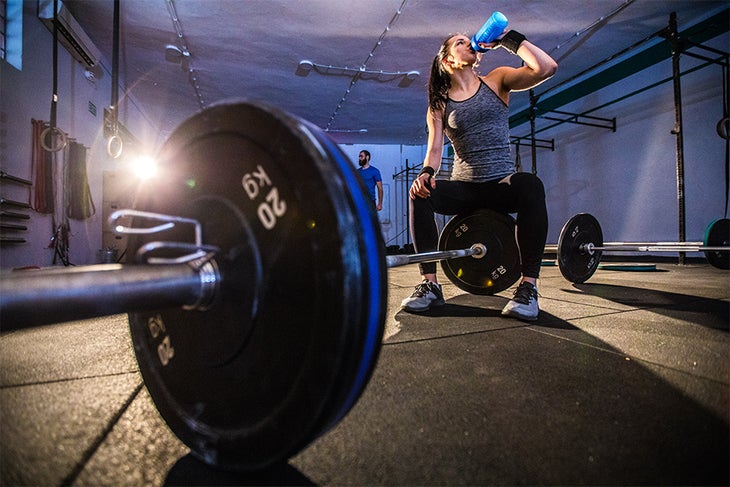 Now Sports Image Woman drinking preworkout before lifting at the gym