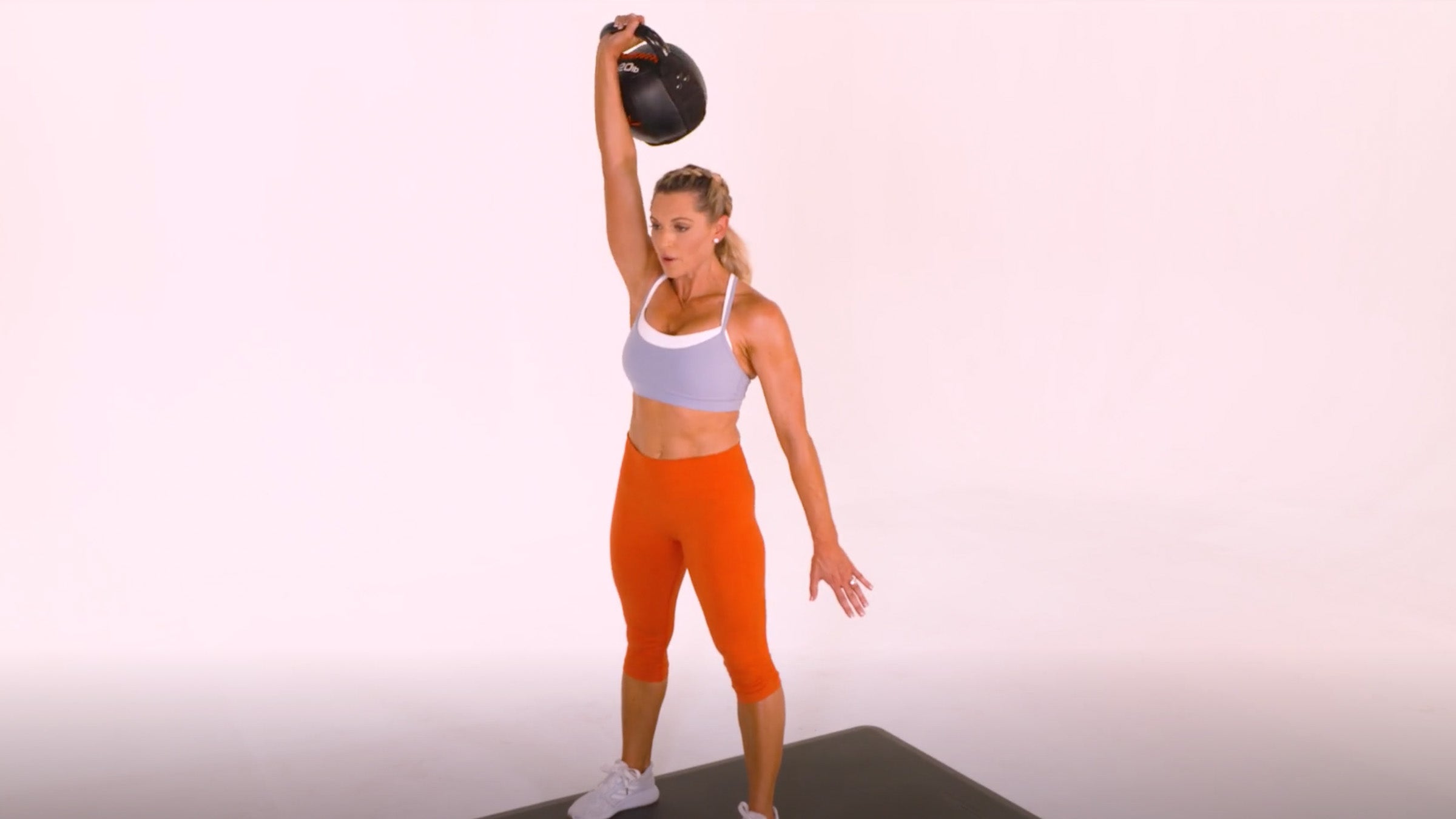 Woman demonstrating Kettlebell One-Arm Snatch