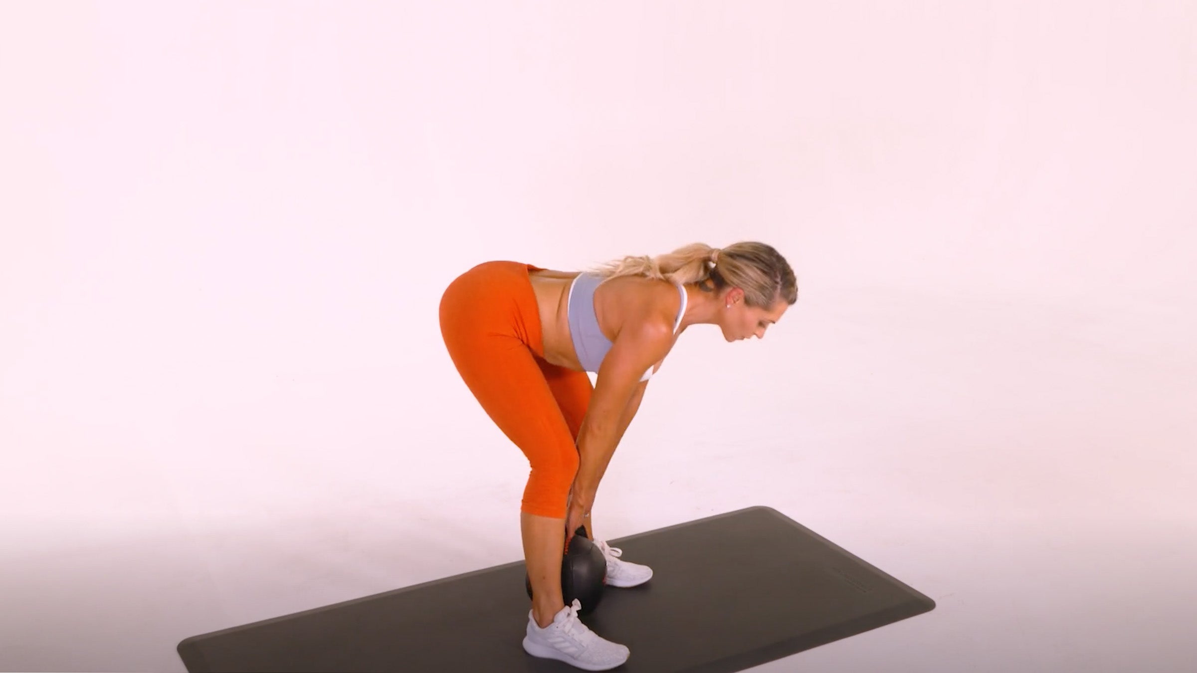 Woman demonstrating Kettlebell Stiff-Legged Deadlift