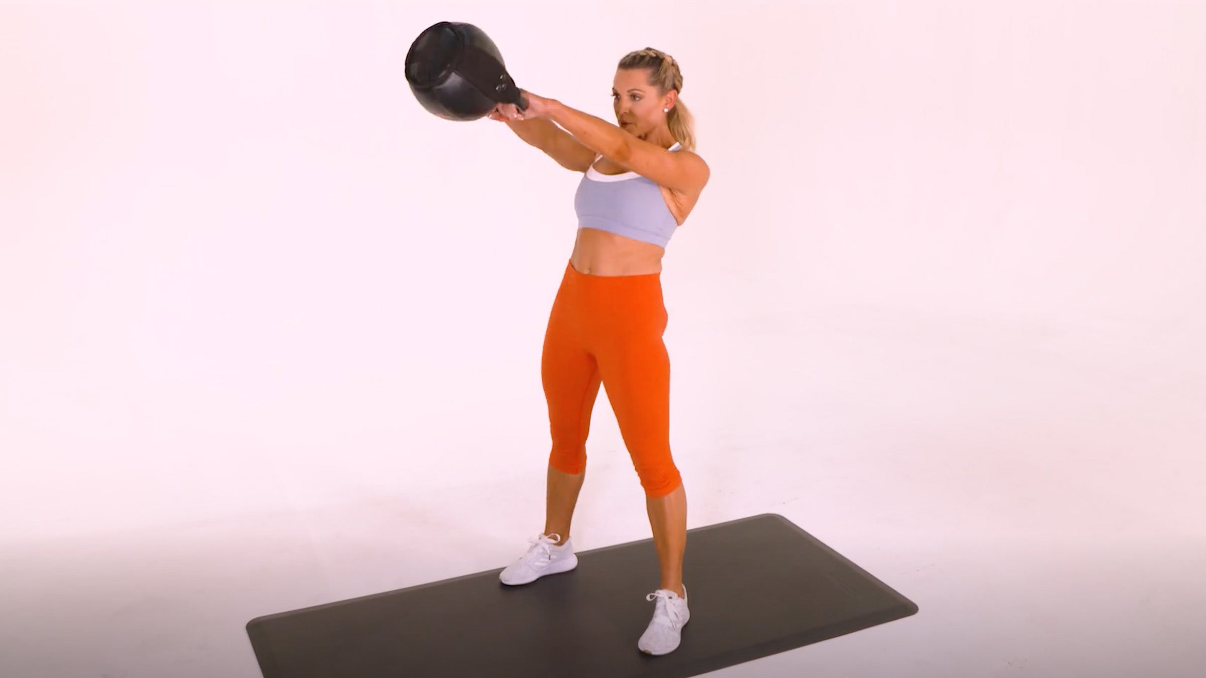 Woman demonstrating Kettlebell Two-Arm Russian Swing