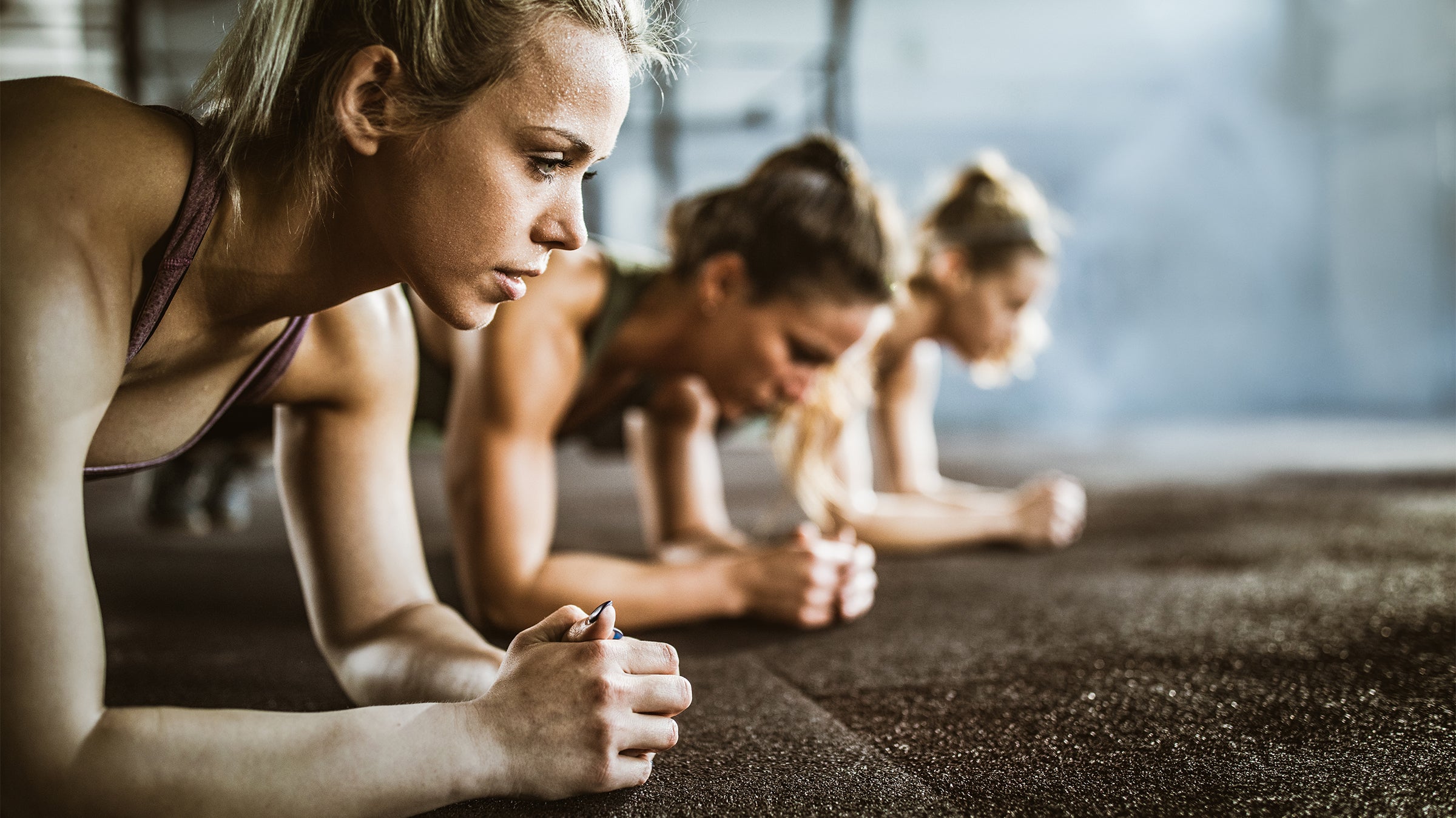 Three women doing a plank for abs