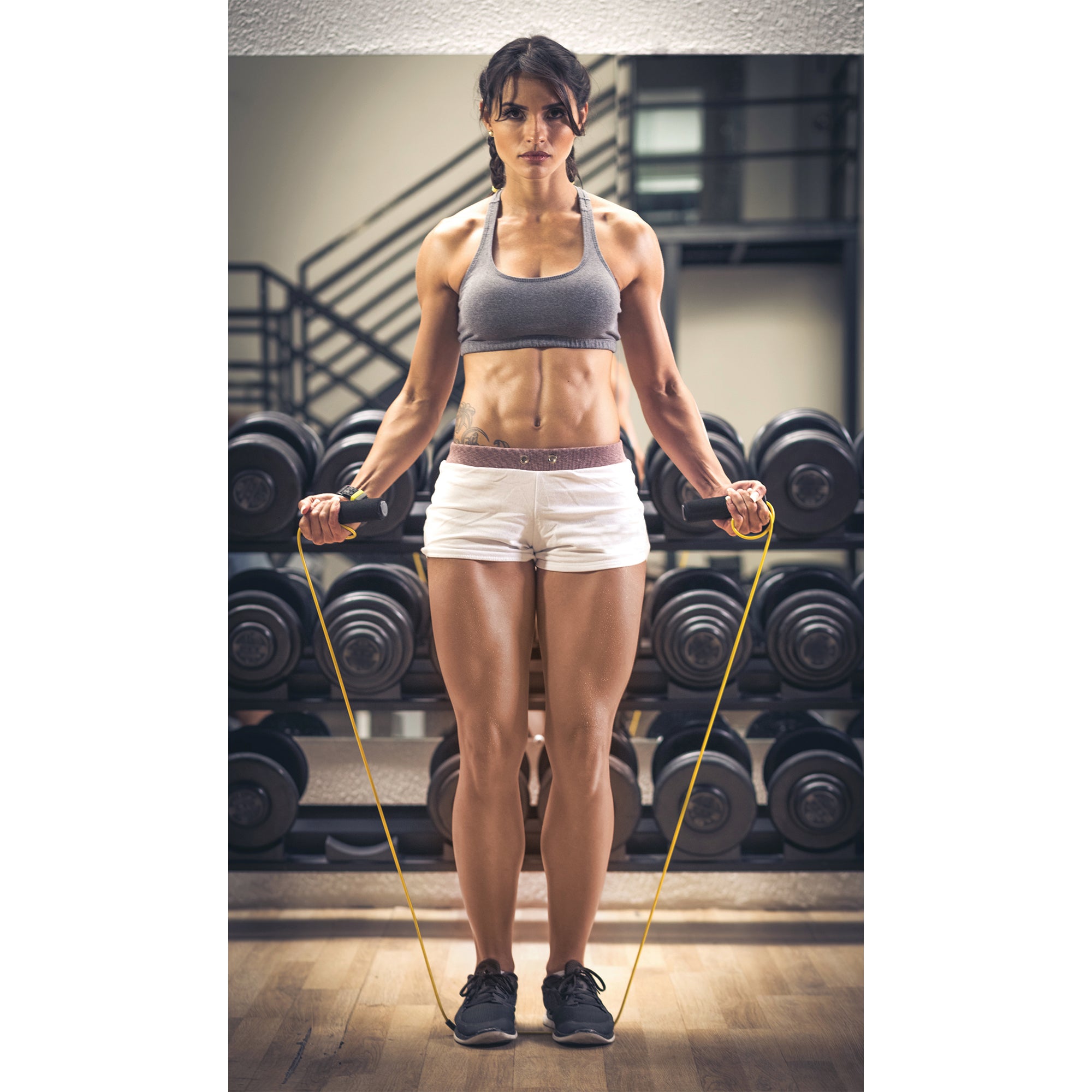 Woman standing on a jump rope at the gym